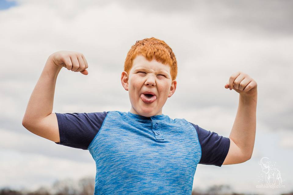 13-year-old boy flexes his muscles and makes silly faces
